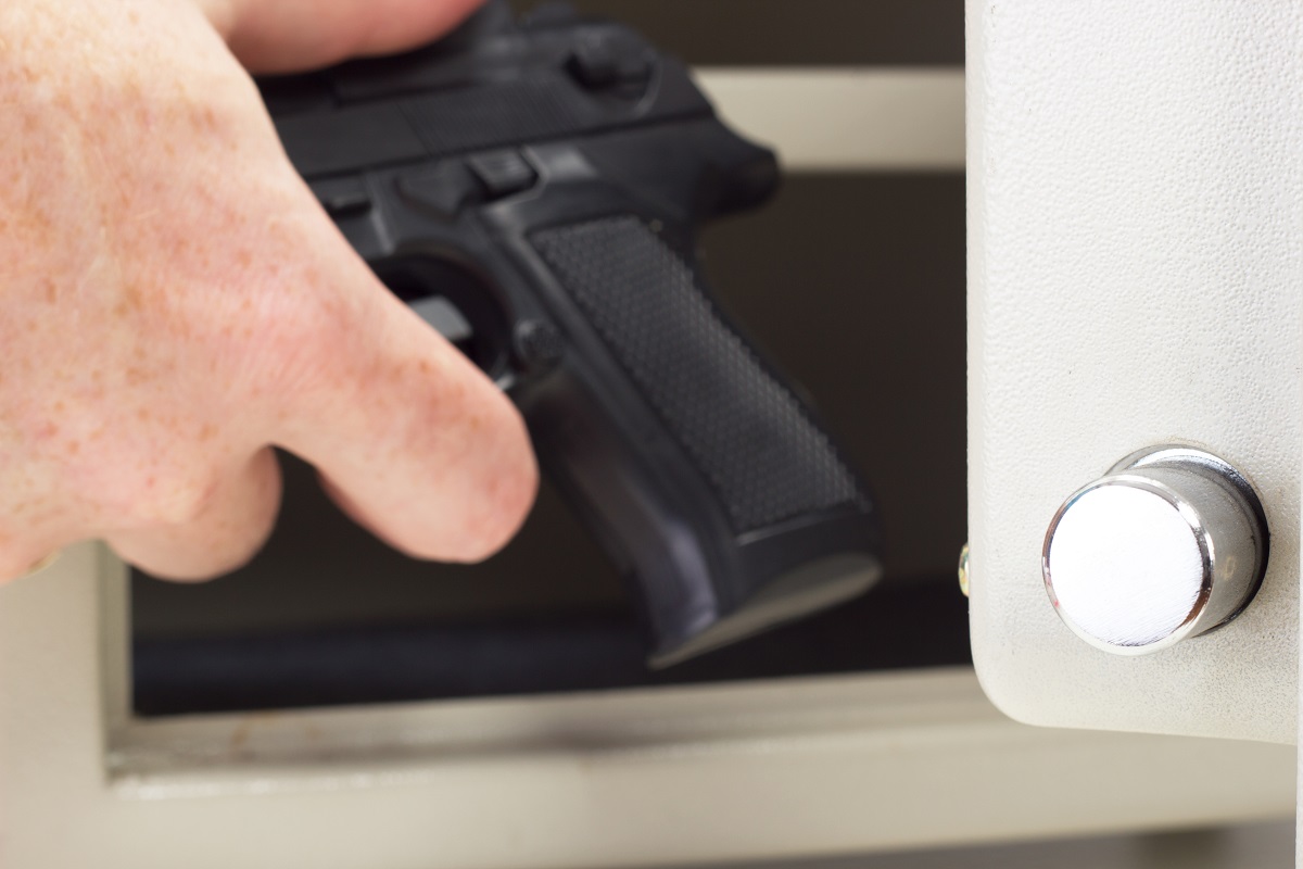 Gun owner putting the firearm in the safe