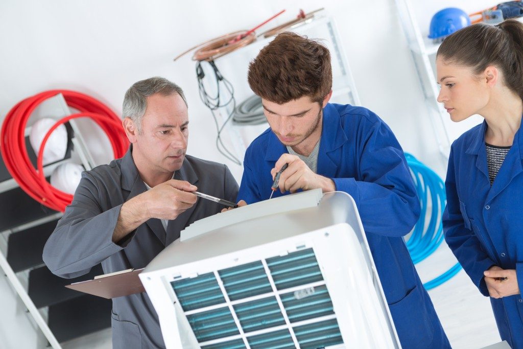 Technicians repairing the AC