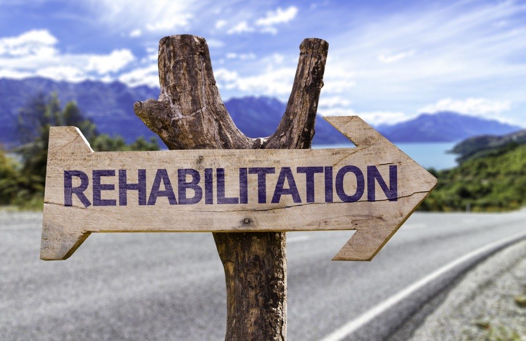 Rehabilitation wooden sign with a road background