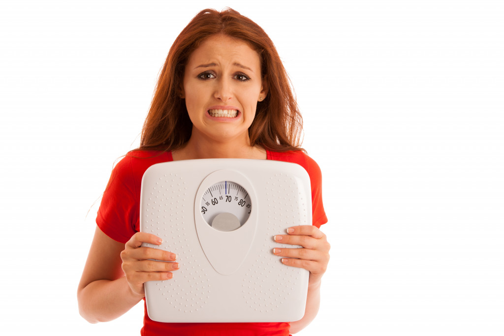 holding a weighing scale