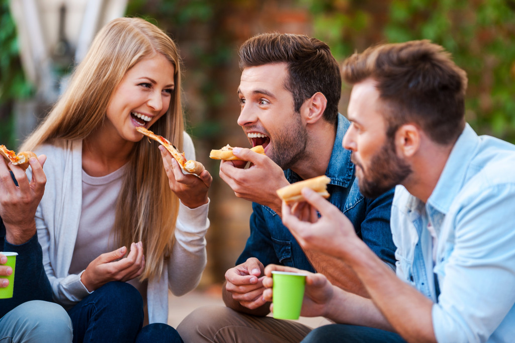 Pizza lovers. Group of playful young people eating pizza while having fun together