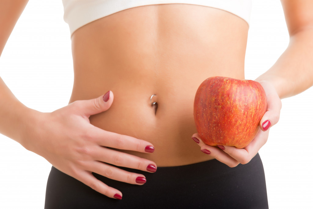 fit woman holding an apple