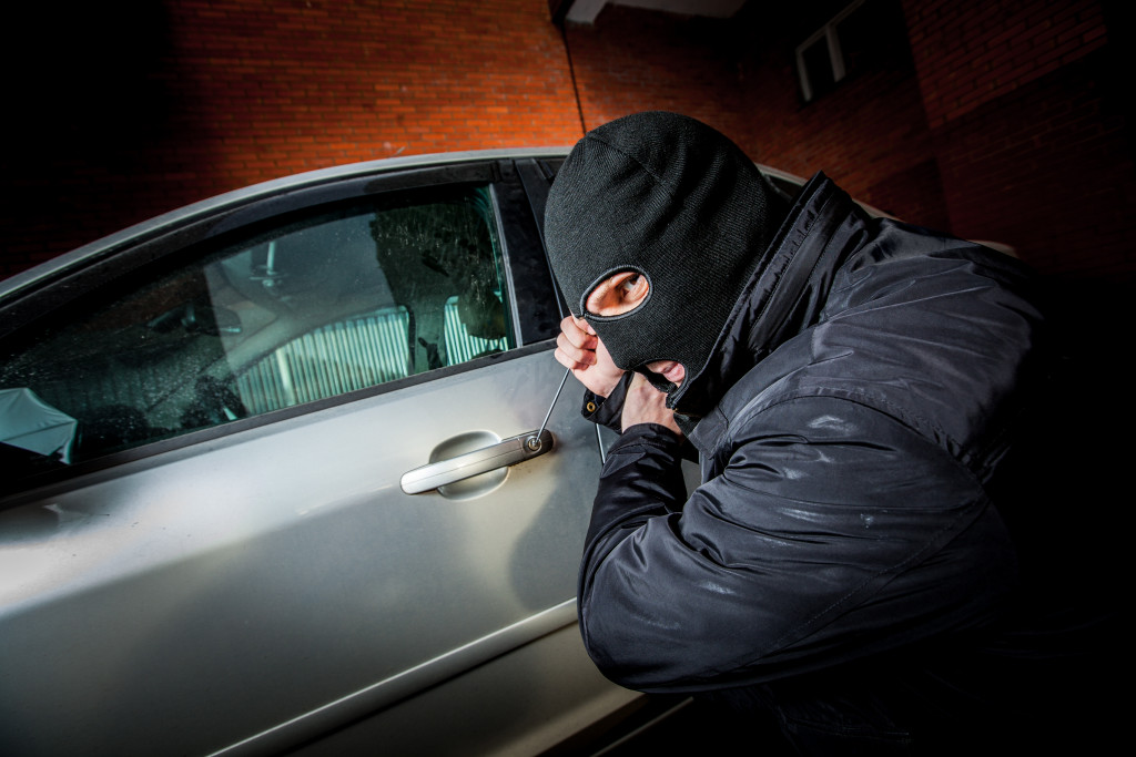 male robber trying to open a car