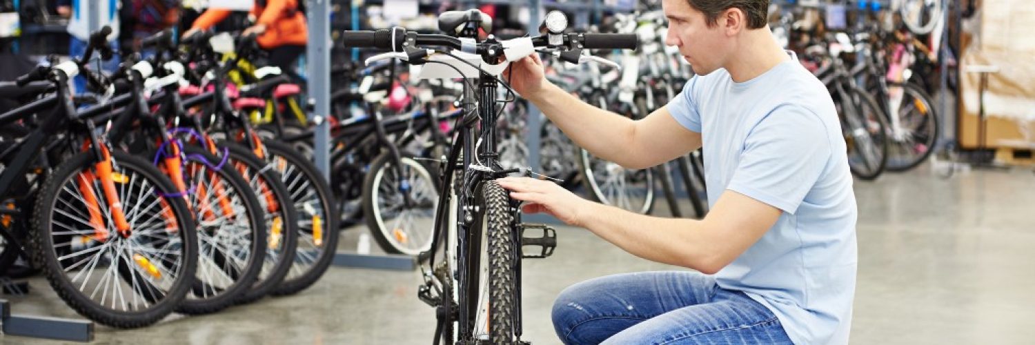 man choosing a bike to buy in a sports shop