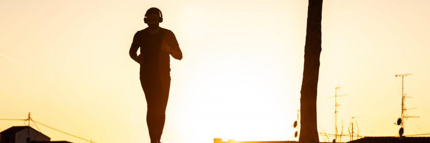 healthy man running in sunrise with silhouette